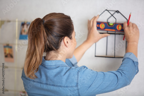 a woman measures the level of a frame