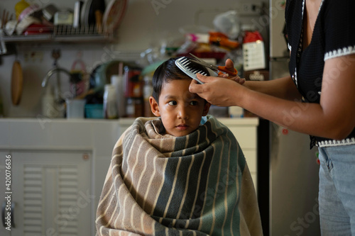 An Asian mother Haircut off her childhood son in the home.