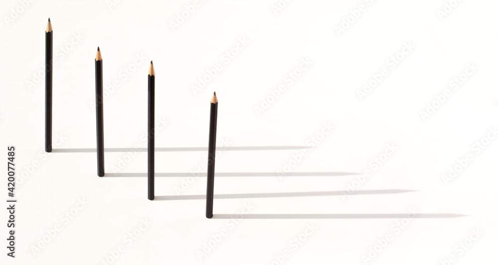 black pencils stand upright and shadow. The concept of leadership and business black pencils stand upright and shadow. The concept of leadership and business