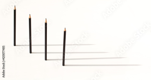 black pencils stand upright and shadow. The concept of leadership and business