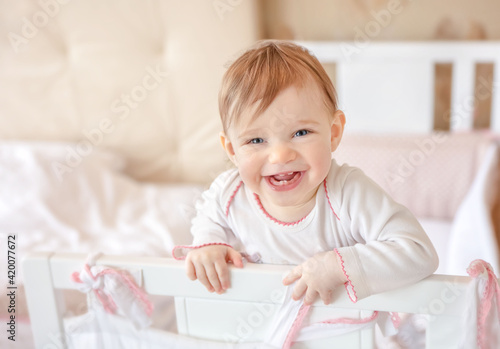 Smiling baby at home. Happy child in white nursery.
