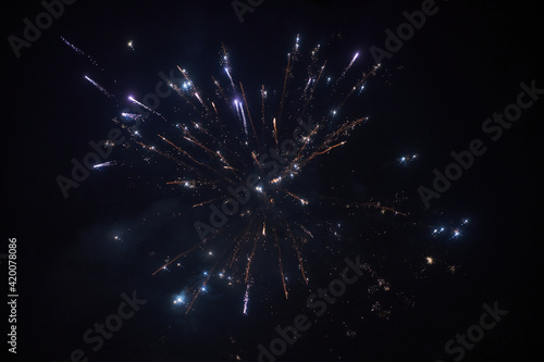 Light trace with bright burst and sparks from firework blowing up at dark night sky, long exposure