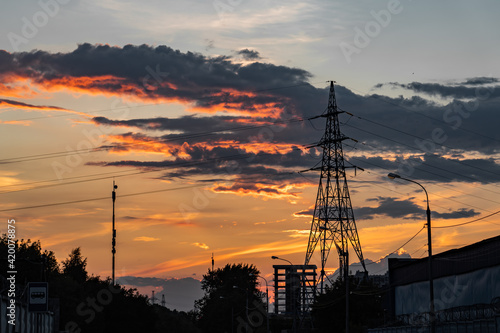 High-voltage power lines over sunset background