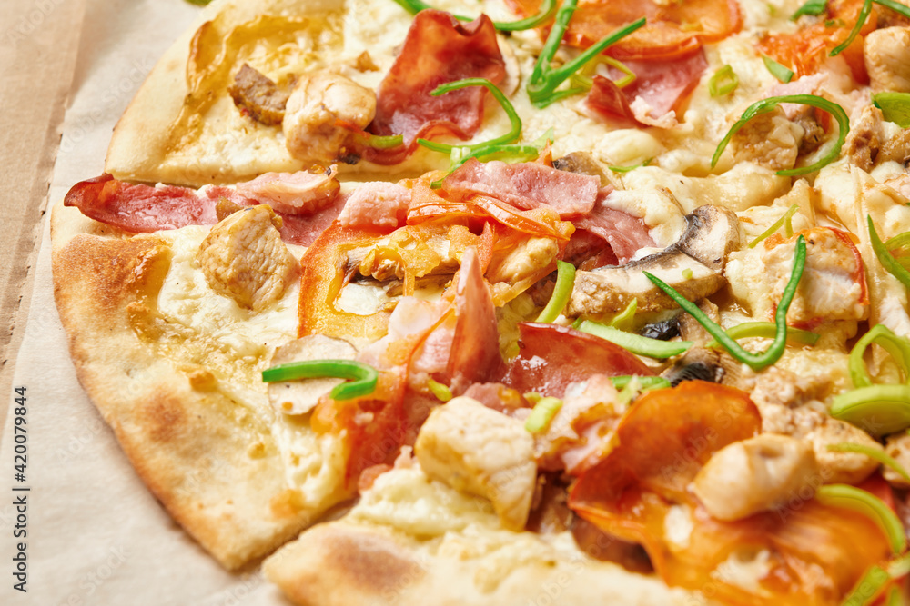 Delicious sliced pizza in carton box. Tasty italian pizza on thin crusty with cheese mozzarella, tomatoes, bacon, chicken and green onion. Close up view. Delicious sliced pizza in carton box. Tasty italian pizza on thin crusty with cheese mozzarella, tomatoes, bacon, chicken and green onion. Close up view.