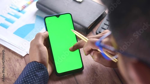  rear view of man hand using smart phone on office desk  photo