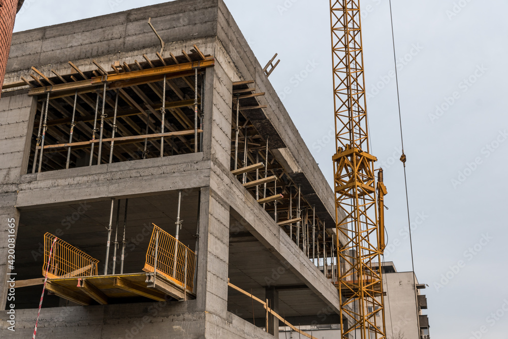 Close up of new residential building construction site with part of the crane machinery 