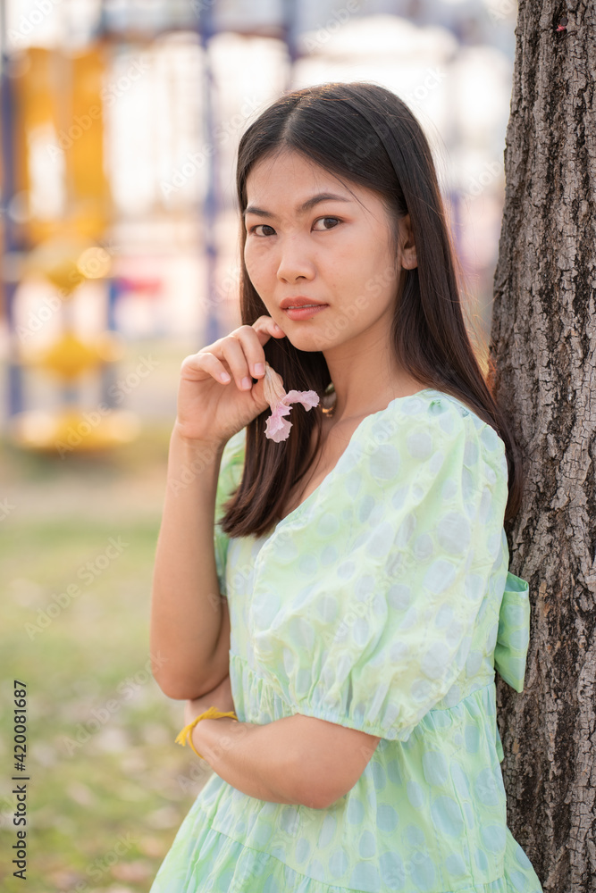Beautiful women with pink sakura flower in fall autumn park Beautiful women with pink sakura flower in fall autumn park