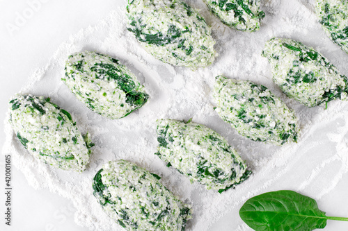 Cooking Gnudi with ricotta and spinach on white board. Italian meal