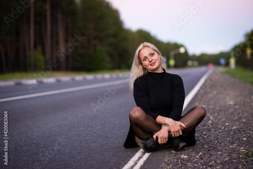 blonde girl in black dress on the road, selective focus © Ekaterina