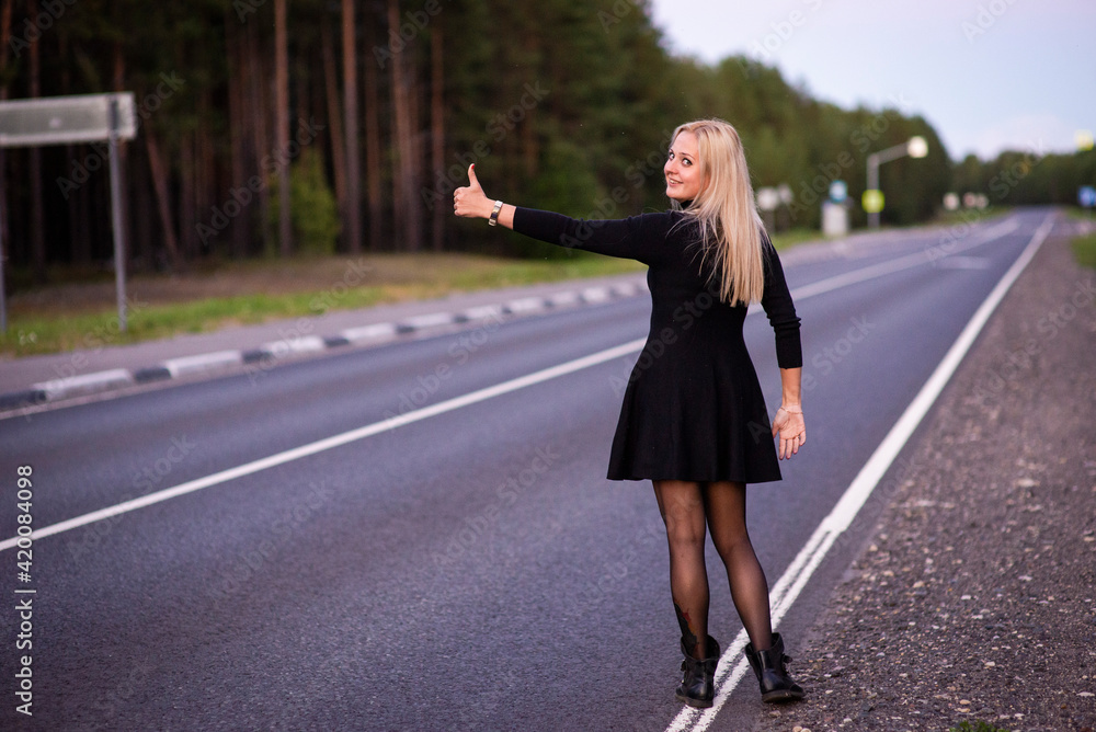 blonde girl in black dress on the road, selective focus blonde girl in black dress on the road, selective focus