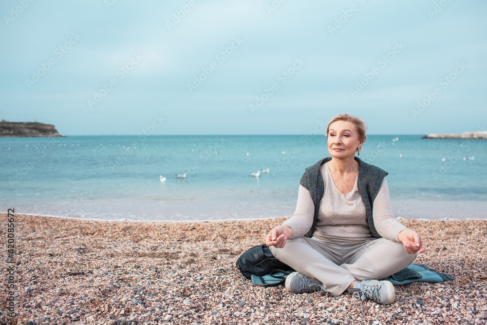 Beautiful middle-aged woman walking in the beach of the sea Beautiful middle-aged woman walking in the beach of the sea