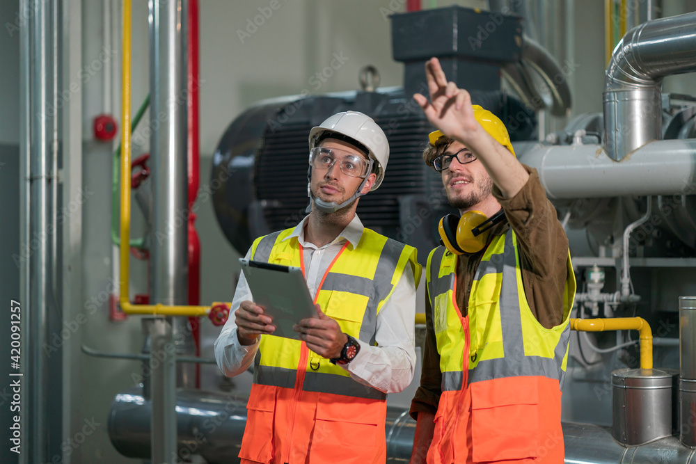 Two industry engineers having discussion work plan in the factory Two industry engineers having discussion work plan in the factory