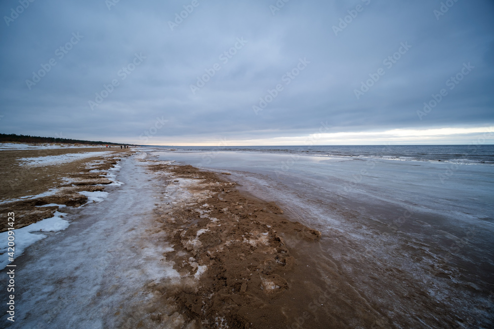 icy winter beach near the sea with frozen sand and ice blocks in the water icy winter beach near the sea with frozen sand and ice blocks in the water