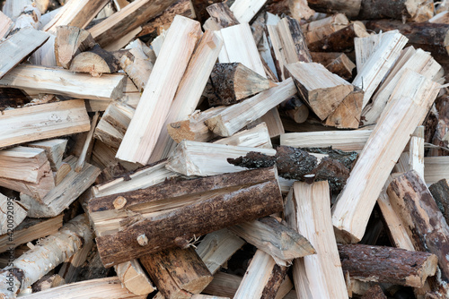 Pile of firewood on a heap. Coniferous and deciduous stacks of firewood.