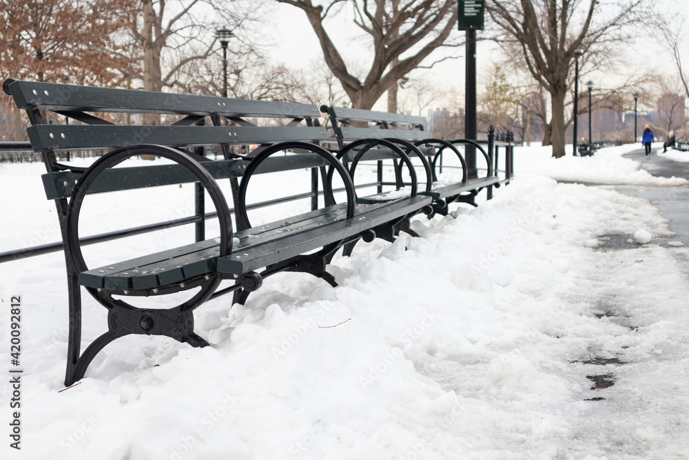 Row of Empty Wood Benches at Astoria Park in Astoria Queens New York with Snow on the Ground during Winter