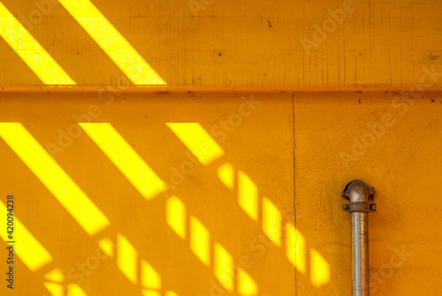 Yellow wall with metal downpipe