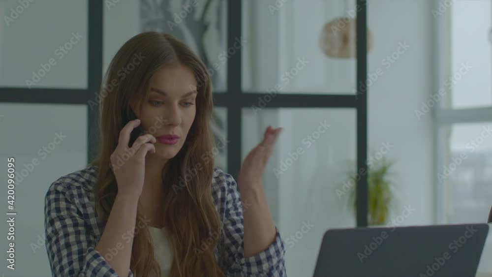 Female employee talking mobile office. Confused woman using smartphone Female employee talking mobile office. Confused woman using smartphone