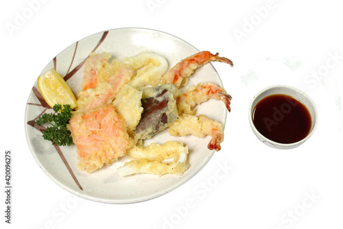 the seafood fried in batter in a plate with sauce it is isolated a white background