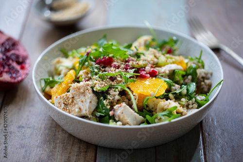 Salad with buckwheat, orange and pomegranate seeds, chicken and halloumi