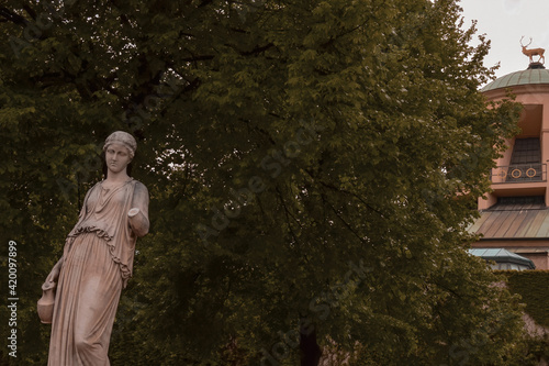 Photo of a city Park with a sculpture of a woman holding a jug