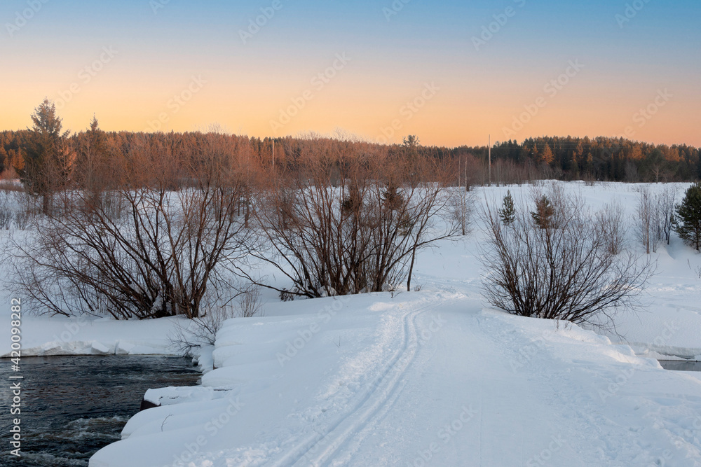 winter road across the river overlooking the snowy edge of the forest winter road across the river overlooking the snowy edge of the forest