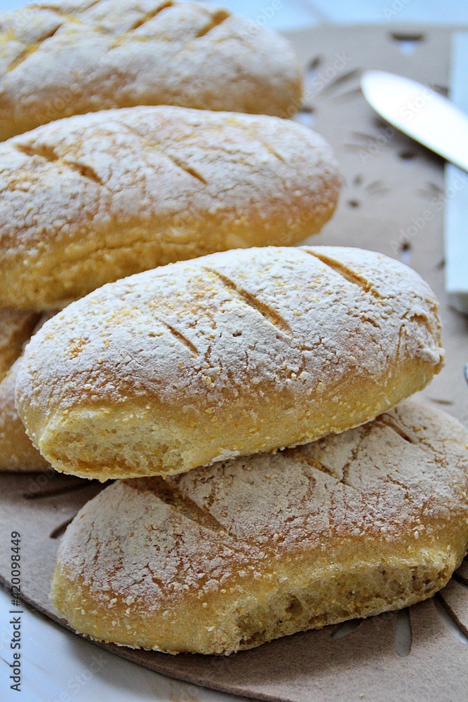 fresh home-made buns with corn flour, small oblong bread sprinkled with flour