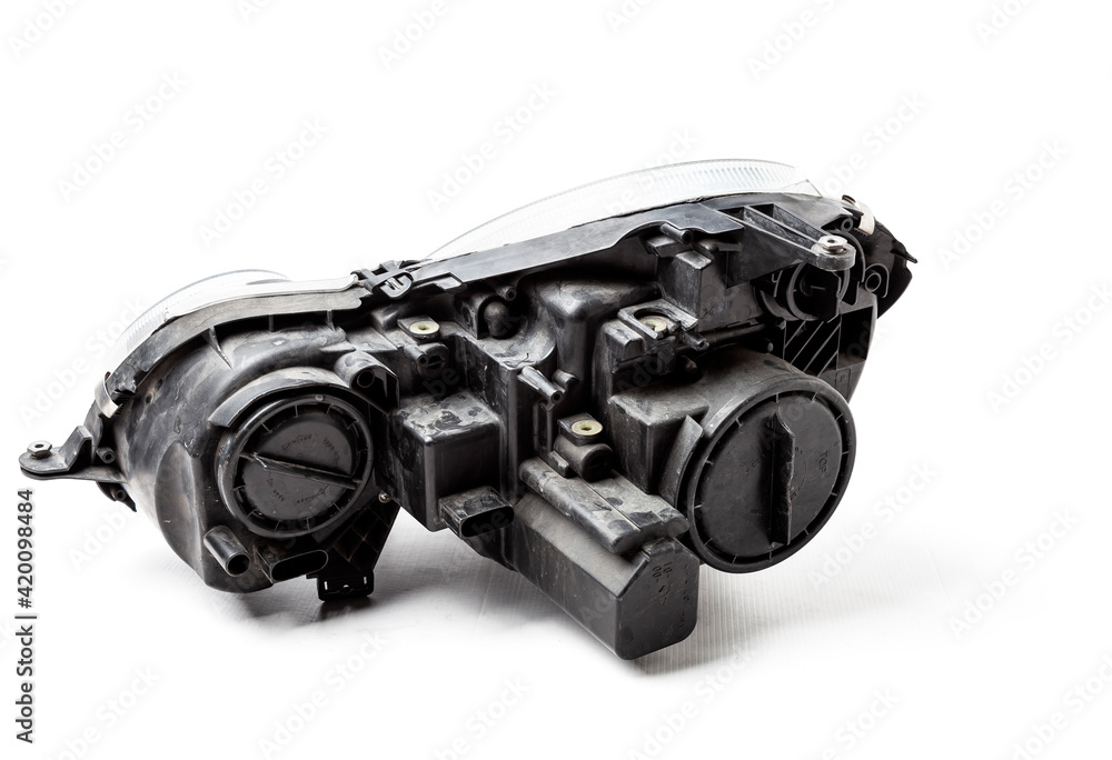 Spare part made of black plastic, rear view on white background in a photo studio for a catalog - a xenon headlight inside electrical systems and optical equipment assemblies of a lamp and reflectors Spare part made of black plastic, rear view on white background in a photo studio for a catalog - a xenon headlight inside electrical systems and optical equipment assemblies of a lamp and reflectors