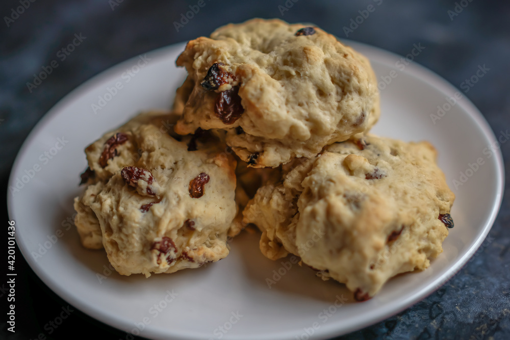 A plate of delicious homemade scones on a white plate with intentional selective focus and bokeh
