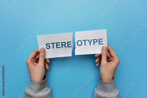 A man tears up a paper with the inscription: stereotype. A symbol of breaking stereotypes in life photo
