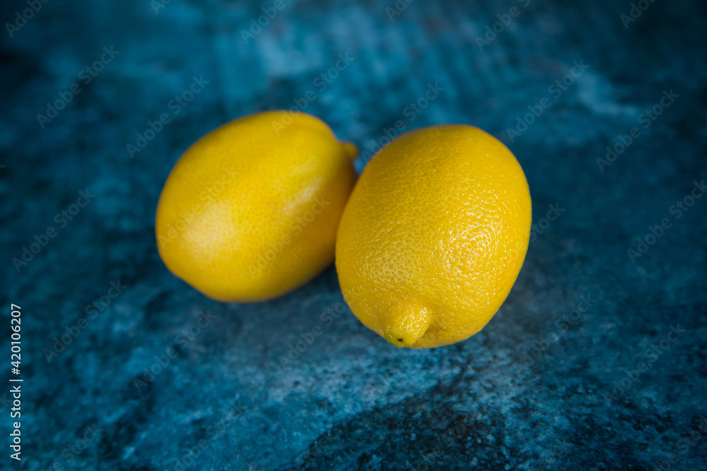 Two lemons on a blue background. Cold medicine. Fruit for lemonade.