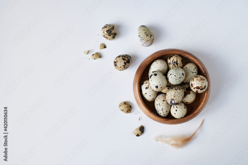 quail eggs in a wooden bowl painted with a feather on a white table. Easter concept Copy space quail eggs in a wooden bowl painted with a feather on a white table. Easter concept Copy space