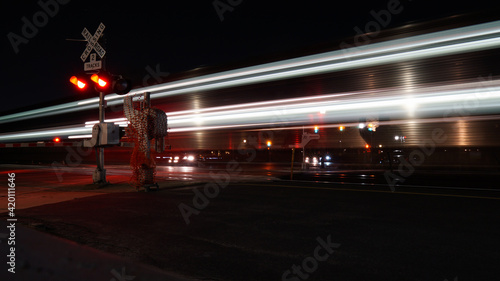 Blurred motion of Metra commuter rail train passing by railroad crossing gates