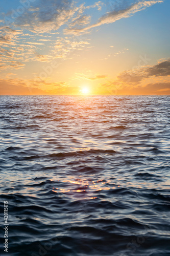 Sunset over the water. Sky with clouds.