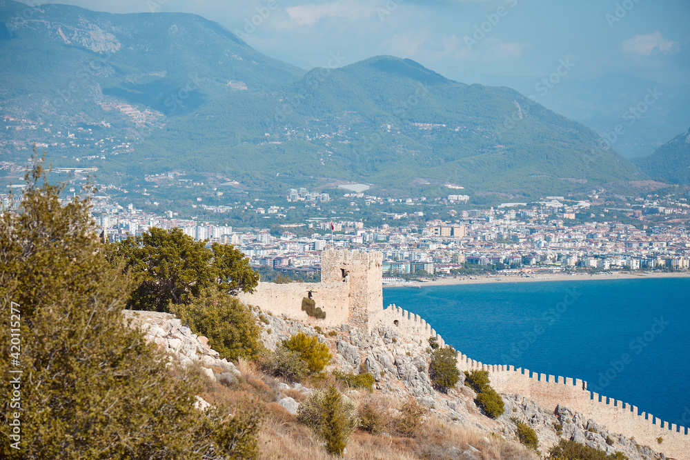 Kizil Kule tower in Alanya peninsula. Beautifullandscape panorama of Alanya Castle in Antalya district, Turkey. Popular tourist destination with high mountains. Summer sunny day and sea 