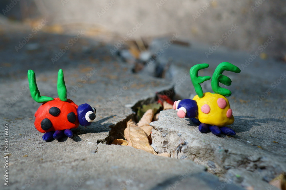 Figurines of two ladybirds made of plasticine. The figures are placed opposite each other. There's a crack between them. Next to it is the inscription life.