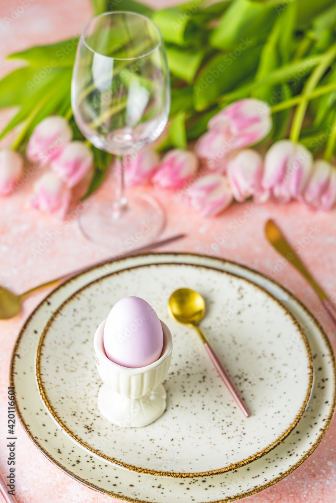 Easter table setting with pink tulip flowers and easter egg Easter table setting with pink tulip flowers and easter egg