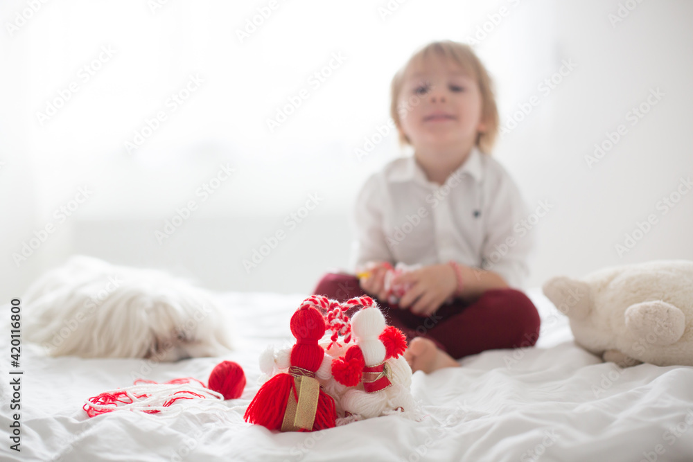 Cute child, blond boy, playing with white and red bracelet Cute child, blond boy, playing with white and red bracelet