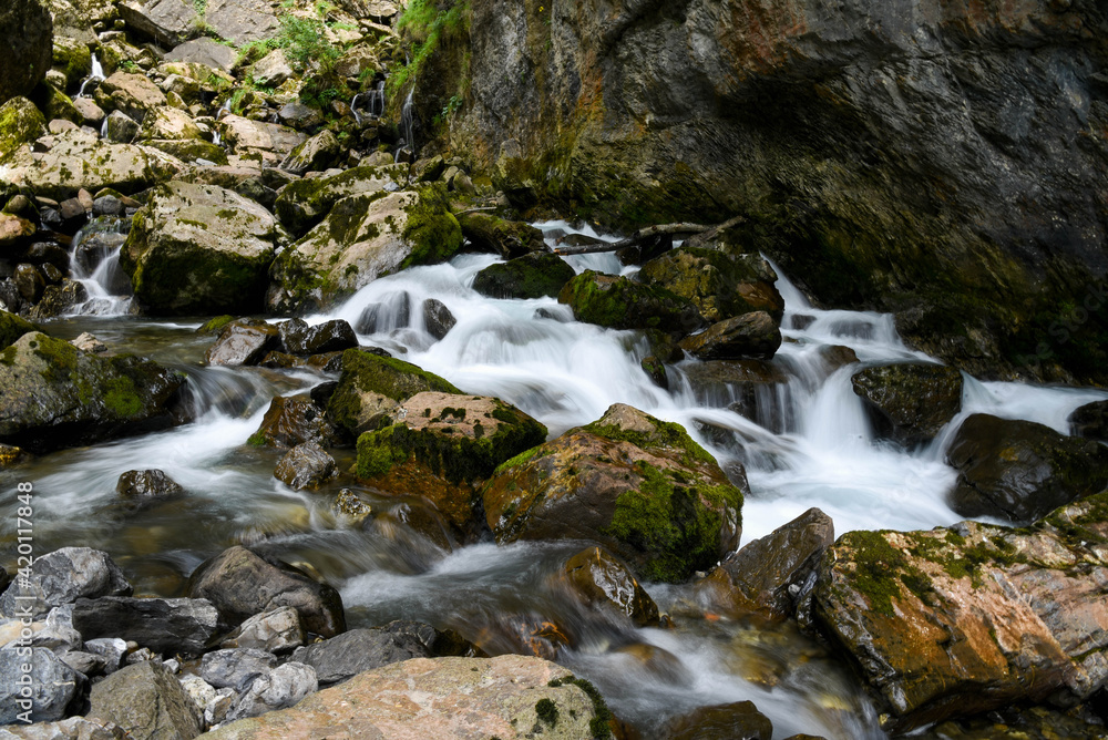 Beautiful photo of rapids and small waterfalls between big moss covered rocks. Beautiful photo of rapids and small waterfalls between big moss covered rocks.
