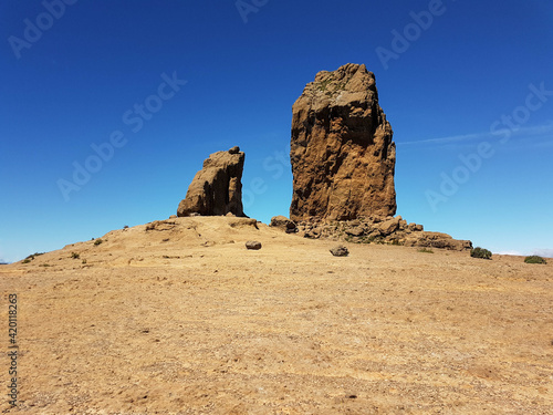 Two huge rocks on a hill below a clear blue sky showing the effect of erosion