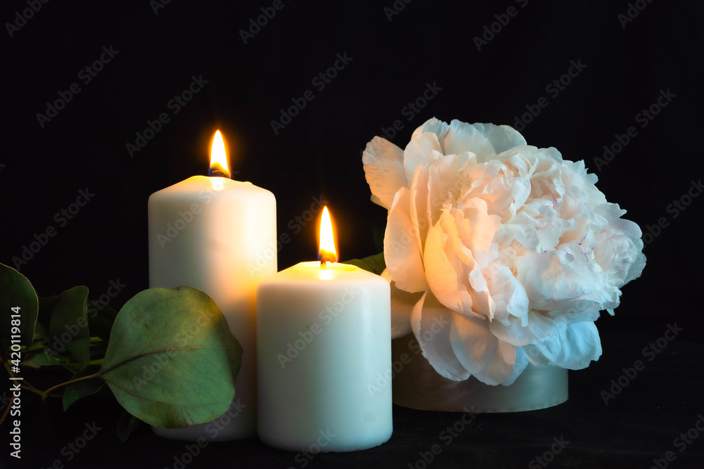 due candele accese e fiori bianchi su uno sfondo nero. condoglianze. vista  frontale Stock Photo | Adobe Stock