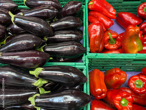 Organic eggplants and red peppers in a grocery