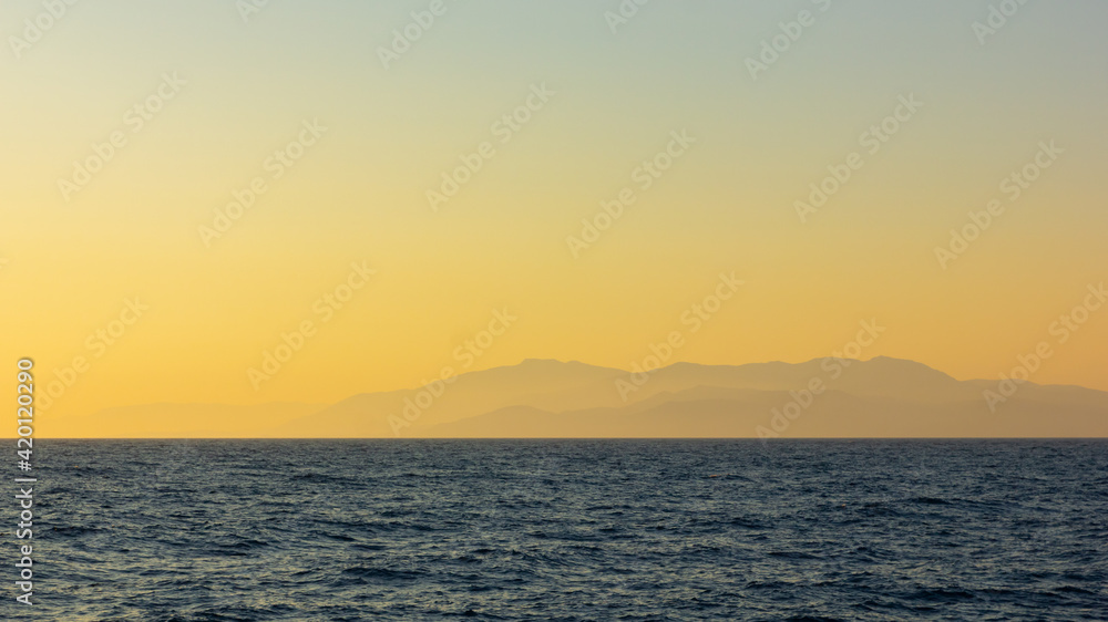 Seascape with fog and mountains. Seascape at sunset. Dramatic scenes and the beauty of nature