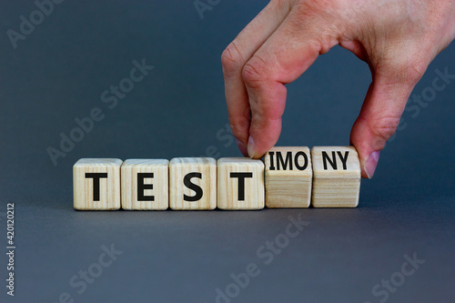 Test or testimony symbol. Businessman turns wooden cubes and changes the word 'test' to 'testimony'. Beautiful grey background. Business, test or testimony concept. Copy space.