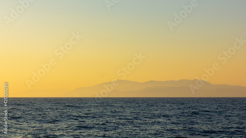 Seascape with fog and mountains. Seascape at sunset. Dramatic scenes and the beauty of nature