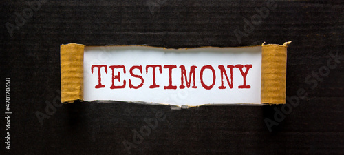 Testimony symbol. The word 'Testimony' appearing behind torn black paper. Beautiful black background. Business, testimony concept. Copy space.