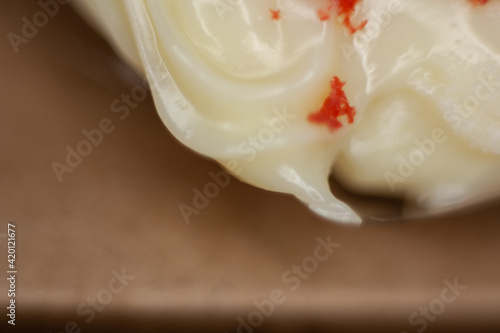 Blur detail next to cream cheese frosting with a piece of red velvet cake. Space for design.