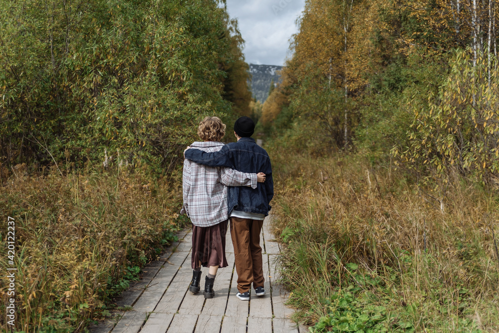 a young couple in love, a man and a woman in the park. romantic outdoor walk a young couple in love, a man and a woman in the park. romantic outdoor walk