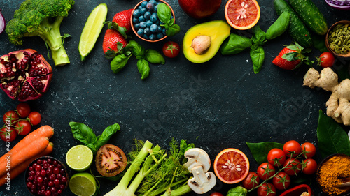 Food. Set of fresh vegetables and fruits on a black stone background. Organic food. Top view. Free space for your text.