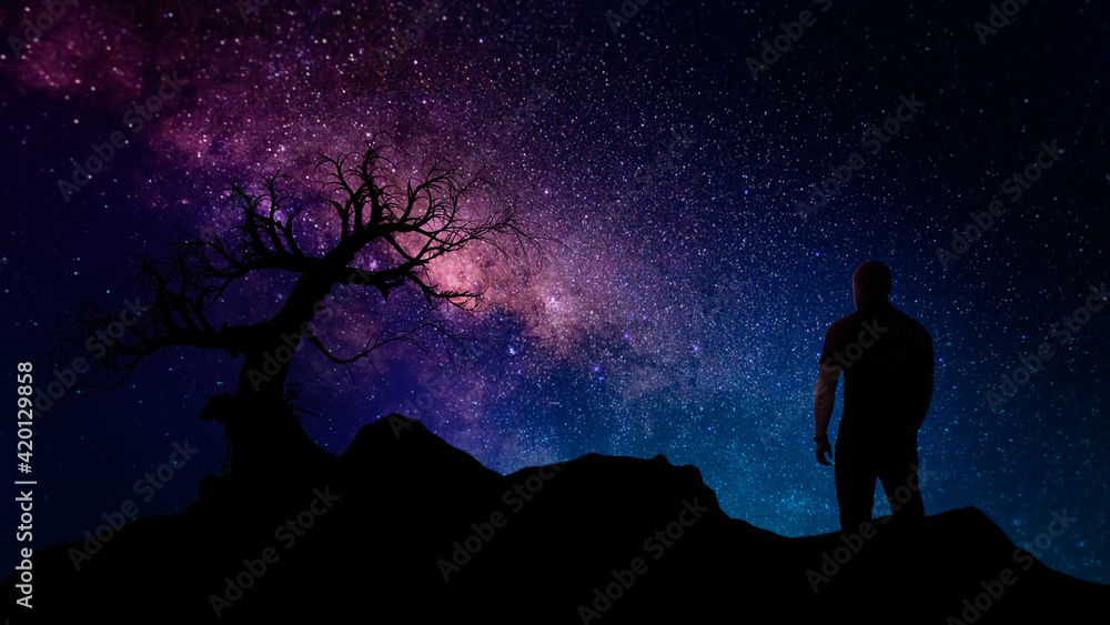 single dead tree and man silhouette at night with milky way core and stars background single dead tree and man silhouette at night with milky way core and stars background