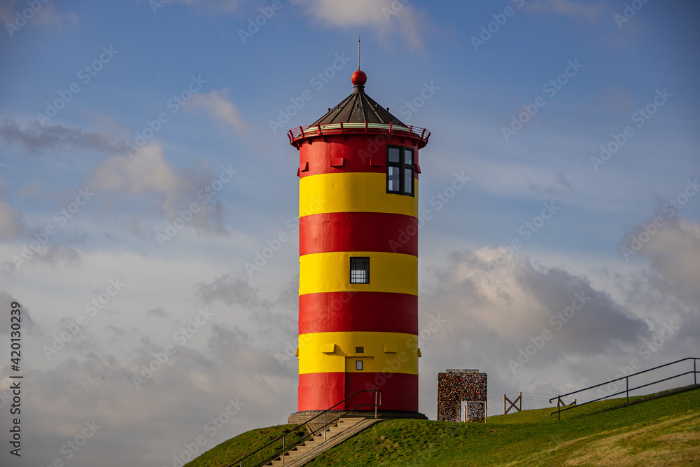 The yellow-red lighthouse of Pilsum in the morning sun